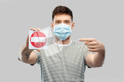 Image of young man girl in medical mask showing stop sign