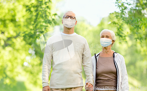 Image of senior couple in protective medical masks outdoors