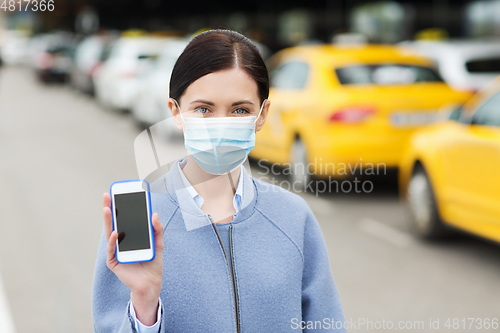 Image of woman in face mask with smartphone in city
