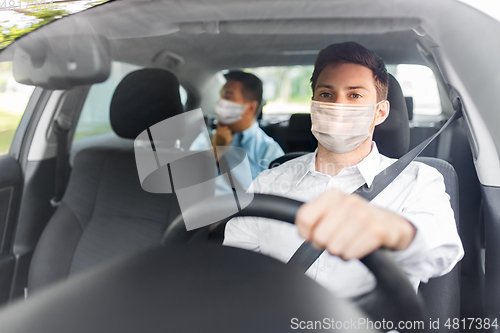 Image of taxi driver in face protective mask driving car