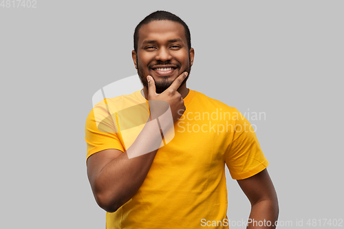 Image of smiling african american man in yellow t-shirt