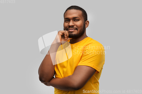 Image of african american man in yellow t-shirt over grey