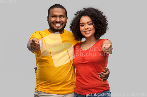 Image of happy african american couple pointing to camera