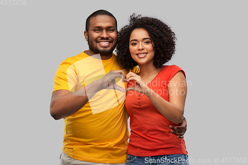 Image of happy african american couple making hand heart