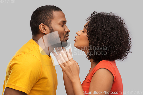 Image of happy african american couple reaching for kiss