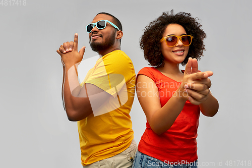 Image of african couple in sunglasses makes finger gun