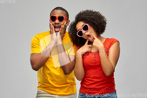 Image of happy african couple in heart shaped sunglasses