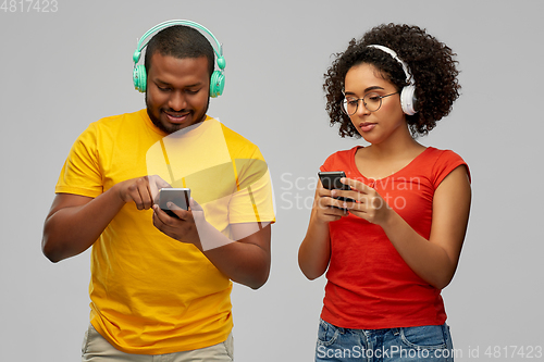 Image of african couple with headphones and smartphones