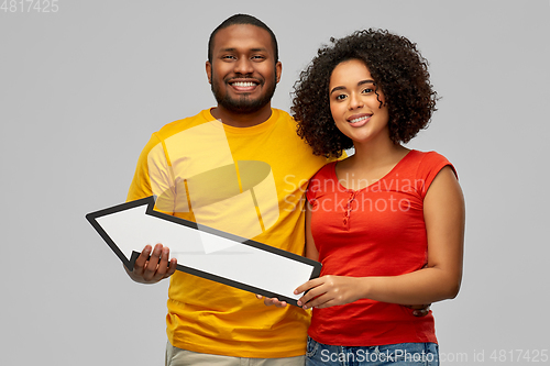 Image of happy african american couple with arrow to left