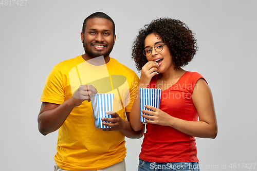 Image of happy african american couple eating popcorn