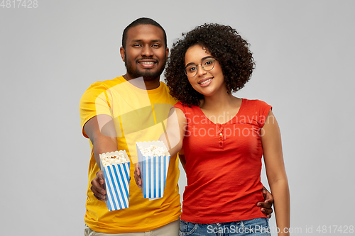 Image of happy african american couple eating popcorn