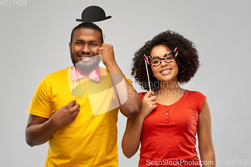 Image of happy african american couple with party props