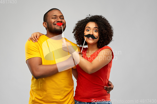 Image of happy african american couple with party props