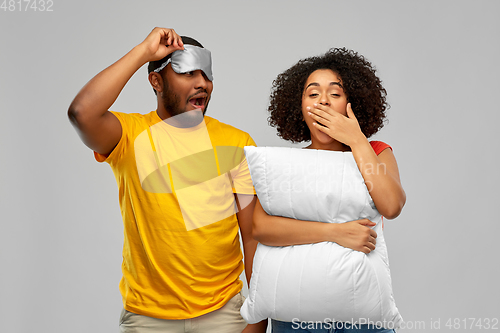 Image of african couple with eye sleeping mask and pillow