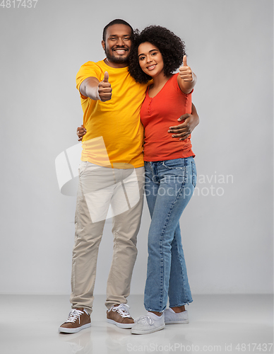 Image of happy african american couple showing thumbs up