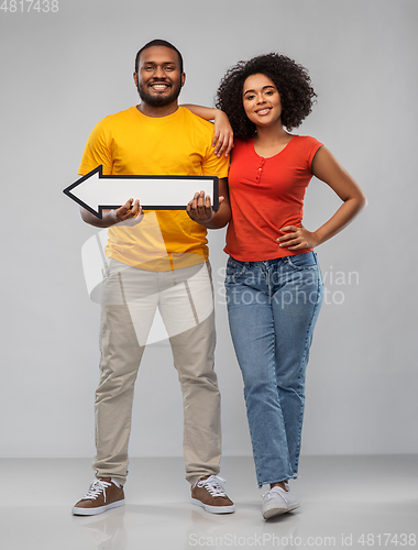 Image of happy african american couple holding arrow
