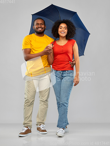 Image of smiling african american couple with umbrella