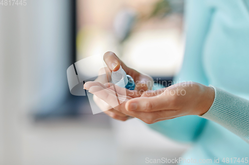 Image of close up of woman spraying hand sanitizer