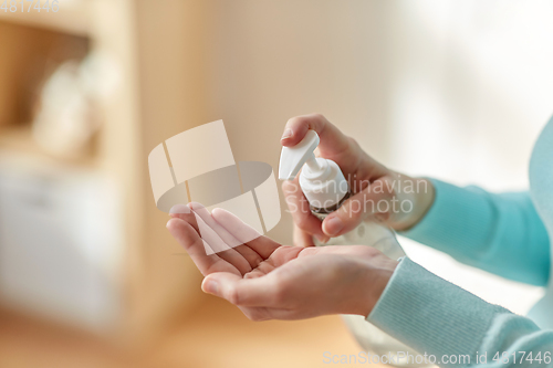 Image of close up of woman applying hand sanitizer