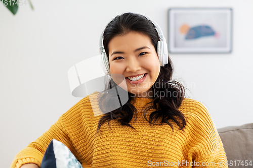 Image of woman in headphones listening to music at home