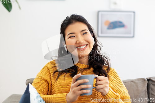 Image of woman in earphones listening to music at home