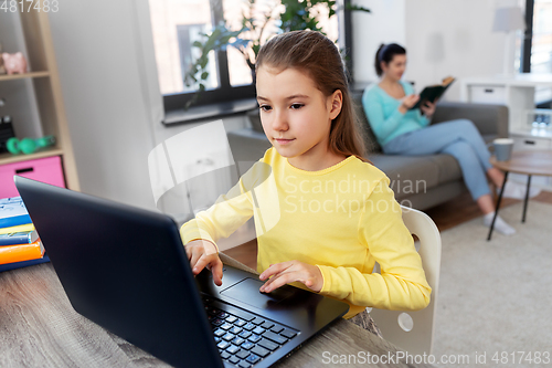 Image of student girl with laptop learning online at home