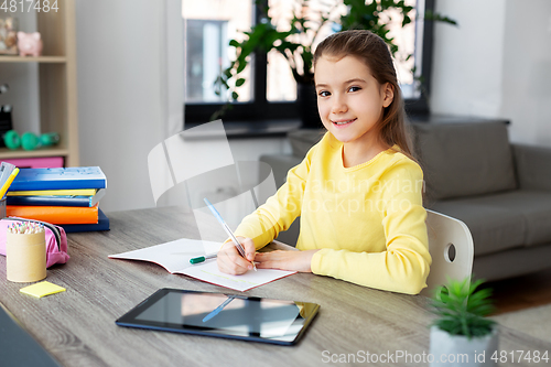 Image of student girl writing to notebook at home