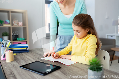 Image of mother and daughter with tablet pc doing homework
