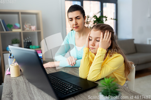 Image of mother and daughter with laptop doing homework