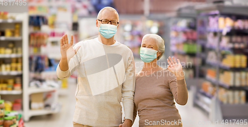 Image of senior couple in medical masks at supermarket