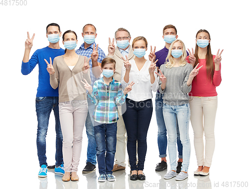 Image of people in medical masks showing peace hand sign