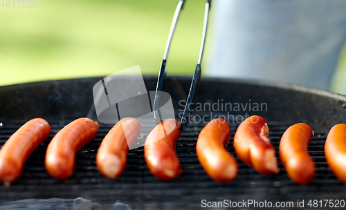 Image of meat sausages roasting on hot brazier grill