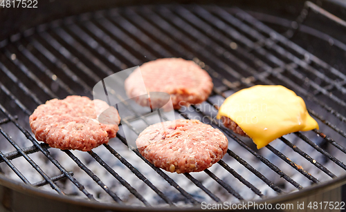 Image of meat cutlet with cheese roasting on barbecue grill