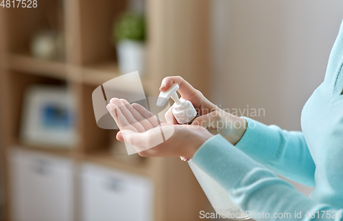 Image of close up of woman applying hand sanitizer