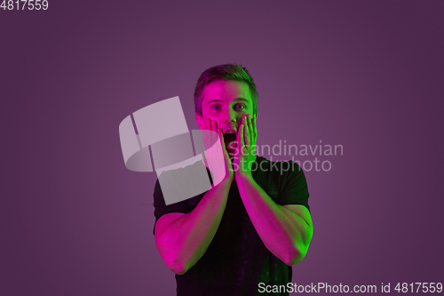 Image of Caucasian man\'s portrait isolated on purple studio background in neon light