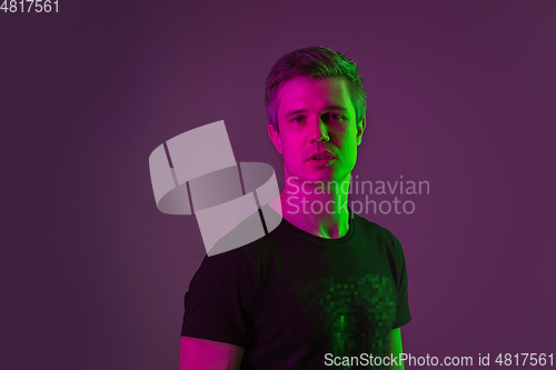 Image of Caucasian man\'s portrait isolated on purple studio background in neon light