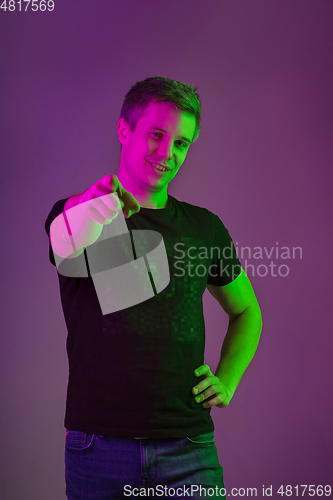 Image of Caucasian man\'s portrait isolated on purple studio background in neon light
