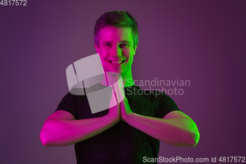 Image of Caucasian man\'s portrait isolated on purple studio background in neon light