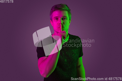 Image of Caucasian man\'s portrait isolated on purple studio background in neon light