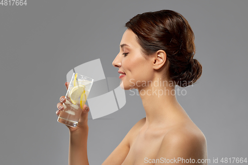 Image of woman drinking water with lemon and ice