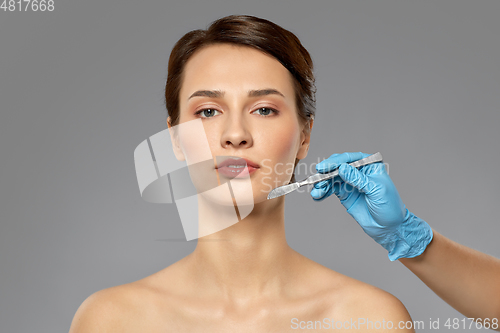 Image of beautiful young woman and hand with scalpel