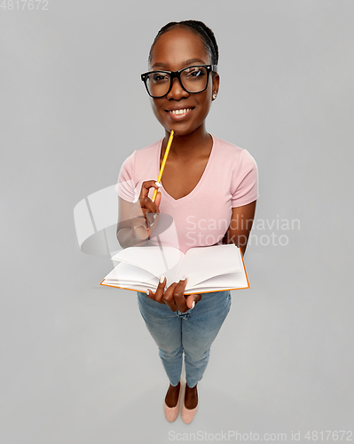 Image of happy african american woman with notebook