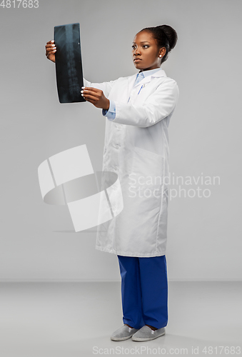 Image of african american female doctor looking at x-ray