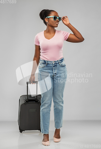 Image of happy african woman in sunglasses with travel bag