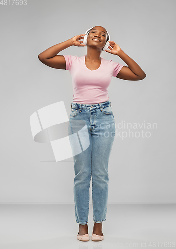 Image of african woman in headphones listening to music