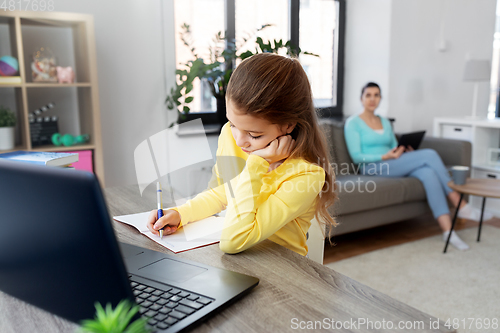 Image of student girl with laptop learning online at home