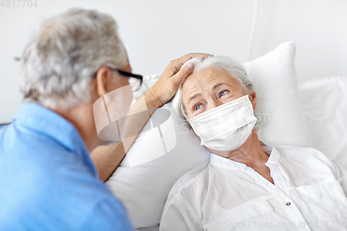 Image of senior couple in face masks meeting at hospital