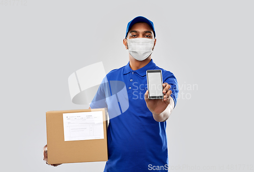 Image of delivery man in mask with cellphone and parcel box