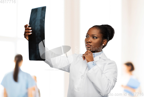 Image of african american female doctor looking at x-ray