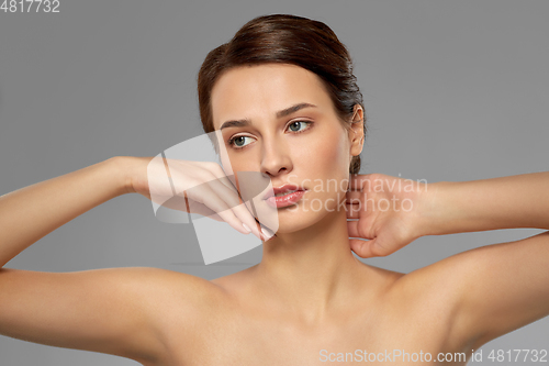 Image of beautiful young woman touching her face